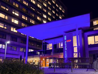 Ein Foto des lila angeleuchteten Hauptgebäude des Klinikums Hanau